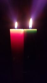 Close-up of illuminated candles in darkroom