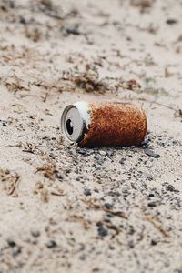 Close-up of abandoned drink can at desert