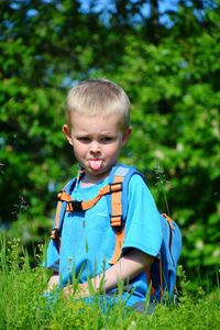 Boy on grass against trees