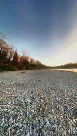 Surface level of stones on beach against sky