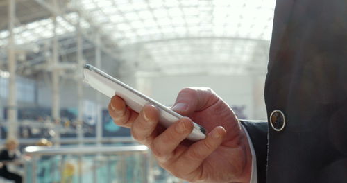 Midsection of man using mobile phone