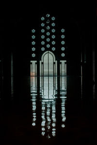 Illuminated building seen through window at night