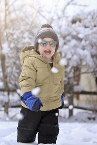 Portrait of young woman standing on snow covered field