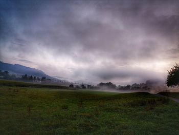 Scenic view of field against cloudy sky