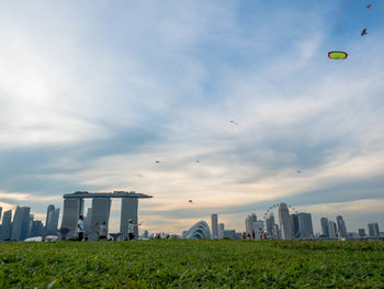 View of buildings in city against cloudy sky