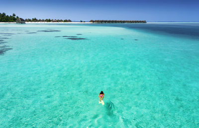 High angle view of woman scuba diving in sea against sky