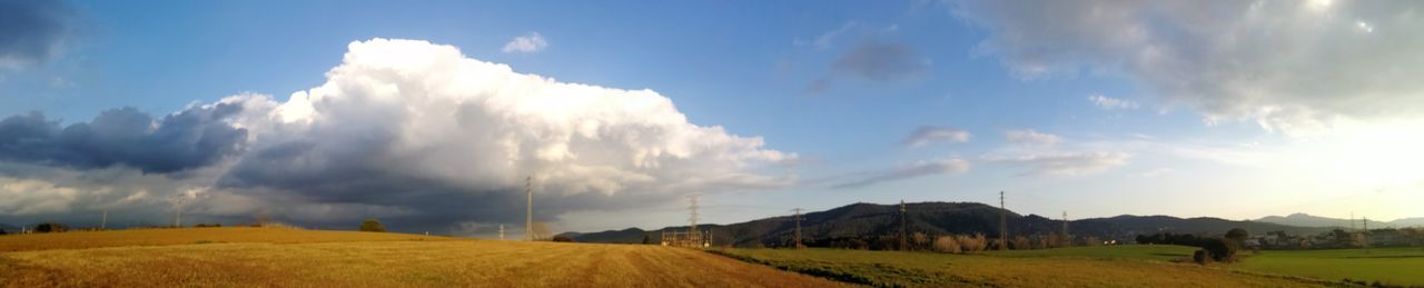 Panoramic view of agricultural field against sky