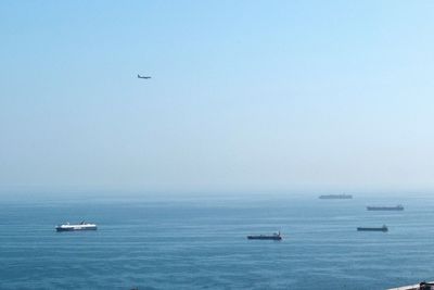 Boats sailing in sea against clear sky