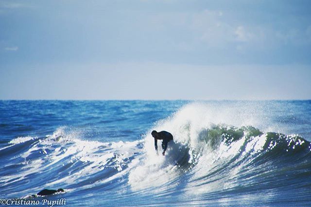 sea, water, horizon over water, wave, motion, surf, splashing, one animal, beauty in nature, one person, scenics, nature, sky, dog, waterfront, animal themes, full length, blue, mammal, pets