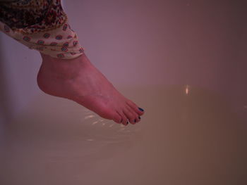 Low section of woman standing on water