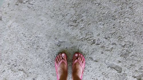 Low section of person wearing flip-flop on footpath