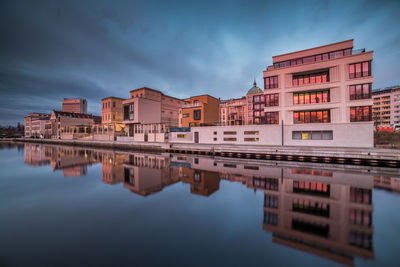 Reflection of buildings in river against sky