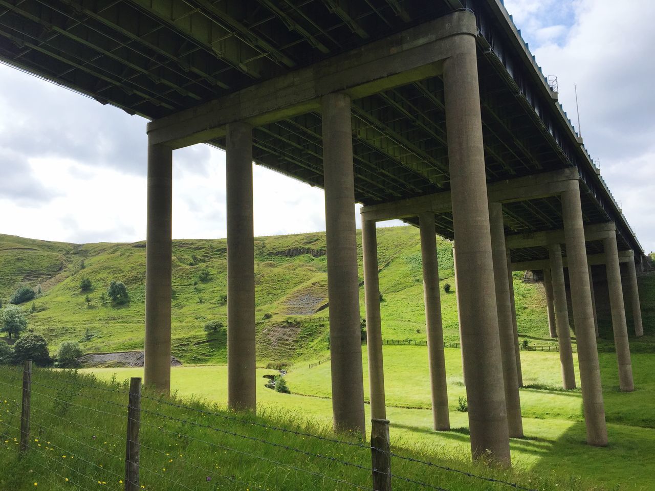 sky, grass, built structure, field, cloud - sky, architecture, landscape, fence, tranquility, cloud, nature, tranquil scene, old, grassy, wood - material, architectural column, day, scenics, cloudy, no people