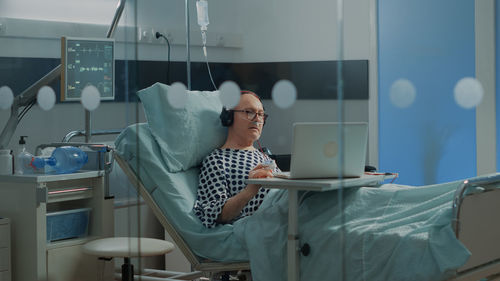 Senior man using computer in hospital