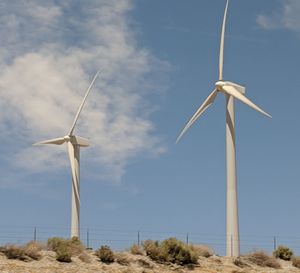 Low angle view of windmill on field against sky