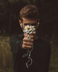 Close-up of girl holding flower against blurred background