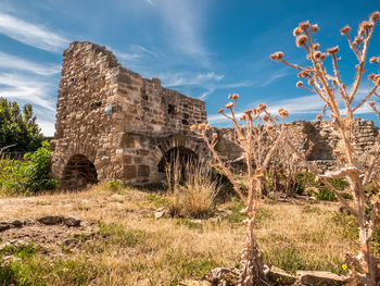 Old ruin on field against sky