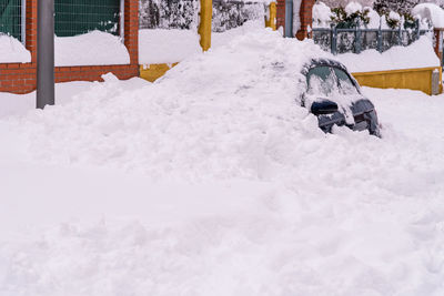 Snow covered car on field