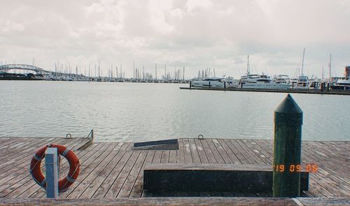 Boats moored in harbor against sky