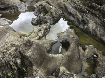 Water flowing through rocks against sky