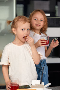Portrait of smiling friends using mobile phone while sitting on table