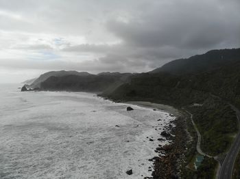 Scenic view of sea and mountains against sky