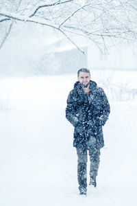 Full length of man standing on snow covered land