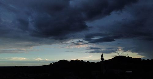 Silhouette of landscape against cloudy sky