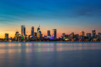 Illuminated buildings in city against sky