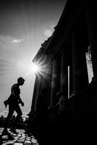 Side view of silhouette woman against bright sun