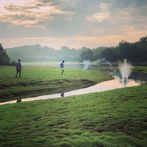 People on field against sky during sunset