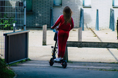 Rear view of woman walking on footpath