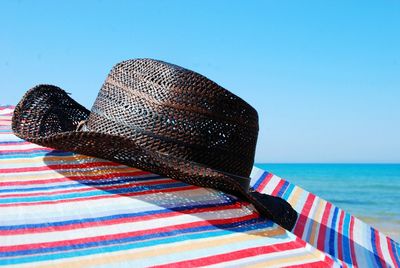 Close-up of hat on beach against sky