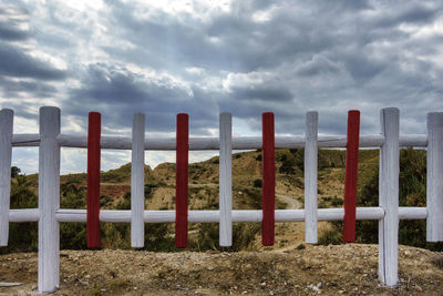 Wooden posts on field against sky