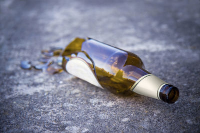 Close-up of broken beer bottle on ground