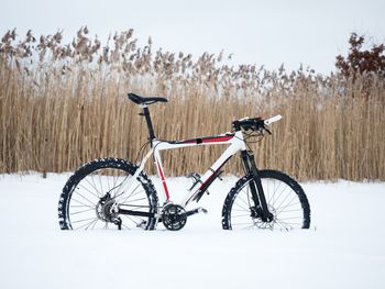 Bicycle parked on snow covered field