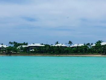 Scenic view of swimming pool by building against sky