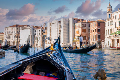 Venetian gondolier punting gondola through grand canal