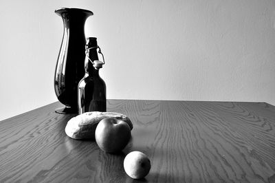 Close-up of apple on table against wall