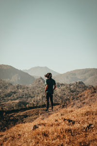 Man standing on mountain against clear sky