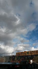 Buildings against cloudy sky