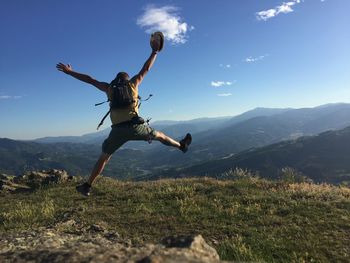 Low angle view of man jumping against clear sky