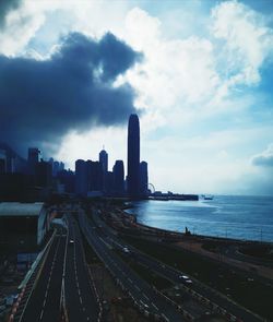 Panoramic view of city buildings by sea against sky