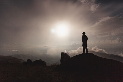 Silhouette man standing against sky during sunset