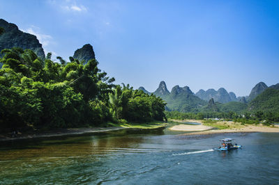 Scenic view of river and mountains against sky