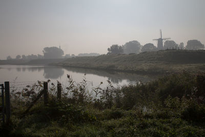 Scenic view of river against sky during foggy weather