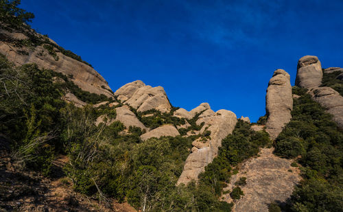 Low angle view of rocks against blue sky