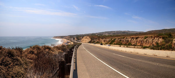 Road by sea against sky