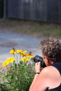 Rear view of woman photographing at camera