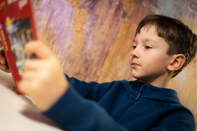 Intelligent boy is reading interesting book